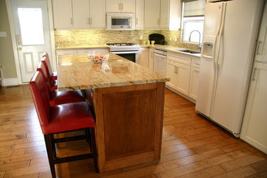 Mid-sized transitional l-shaped medium tone wood floor eat-in kitchen photo in Toronto with an undermount sink, shaker cabinets, white cabinets, granite countertops, beige backsplash, glass tile backsplash, white appliances and an island
