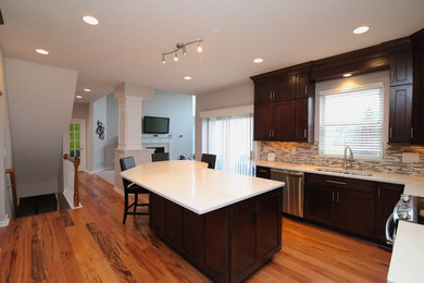 Large minimalist u-shaped medium tone wood floor eat-in kitchen photo in Columbus with an undermount sink, recessed-panel cabinets, dark wood cabinets, quartzite countertops, multicolored backsplash, glass sheet backsplash, stainless steel appliances and an island