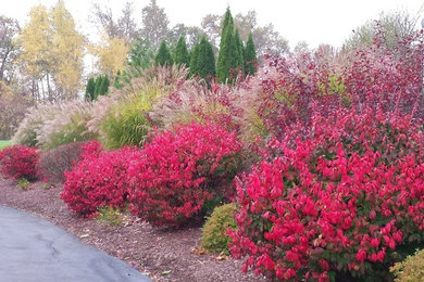 This is an example of a large transitional partial sun front yard mulch driveway in New York.
