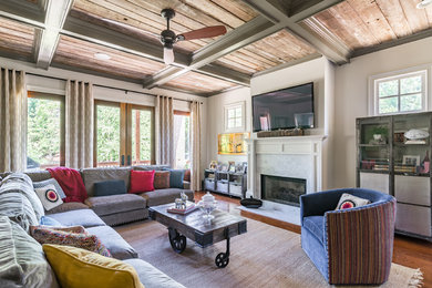 Inspiration for a large timeless enclosed brown floor and dark wood floor family room remodel in Atlanta with a standard fireplace, a wall-mounted tv, beige walls and a plaster fireplace
