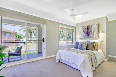 Large contemporary master bedroom in Sydney with a feature wall.
