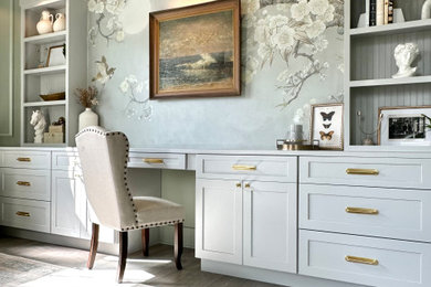 Example of a mid-sized ornate built-in desk laminate floor, gray floor and wallpaper craft room design in Charleston with green walls