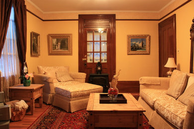 Inspiration for a small transitional enclosed light wood floor family room remodel in Toronto with yellow walls and no fireplace