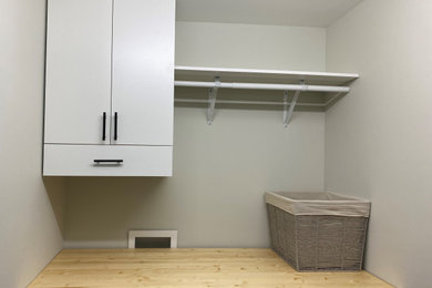 Imagen de armario lavadero lineal bohemio pequeño con armarios con paneles lisos, puertas de armario blancas, encimera de madera, paredes grises y lavadora y secadora juntas