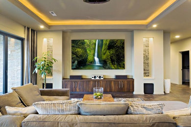 Photo of a large transitional open concept home theatre in Denver with white walls, a projector screen, concrete floors and brown floor.
