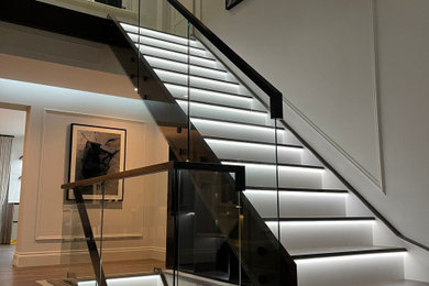 Inspiration for a large contemporary wood straight glass railing staircase in Cheshire with wood risers.