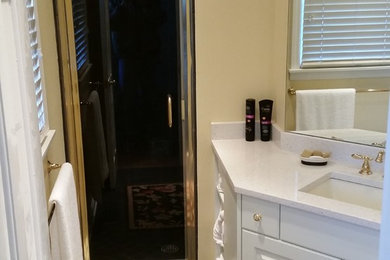 Inspiration for a small timeless master black tile and stone tile slate floor bathroom remodel in Other with an undermount sink, raised-panel cabinets, white cabinets, quartz countertops, a two-piece toilet and yellow walls