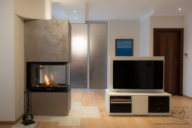 Idee per un soggiorno minimalista stile loft con parquet chiaro, camino bifacciale e TV autoportante