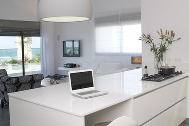 Inspiration for a beach style open plan kitchen in Tel Aviv with flat-panel cabinets and white cabinets.