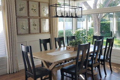 Example of a mid-sized country medium tone wood floor and brown floor great room design in Orange County with beige walls and no fireplace