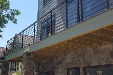 Large contemporary gray three-story vinyl exterior home idea in Other