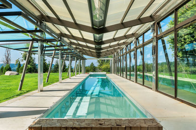 Example of a trendy side yard concrete and rectangular lap pool design in Other