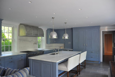 This is an example of a large traditional l-shaped open plan kitchen in Chicago with blue cabinets, marble benchtops, white splashback, stone slab splashback, stainless steel appliances, with island, recessed-panel cabinets, slate floors, an undermount sink and grey floor.