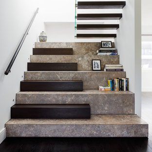 Imagen de escalera en U, actual, grande, con escalones de piedra caliza, contrahuellas de madera y barandilla de madera