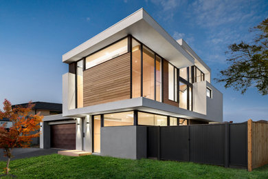 This is an example of a mid-sized contemporary three-storey multi-coloured house exterior in Melbourne with wood siding, a flat roof and a metal roof.