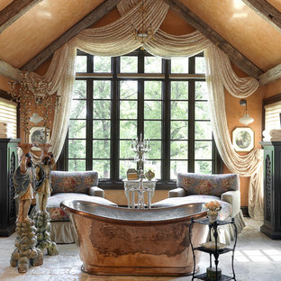 Idées déco pour une grande salle de bain principale méditerranéenne avec une baignoire indépendante, un placard en trompe-l'oeil, des portes de placard en bois sombre, un mur beige, un sol en calcaire et un sol beige.