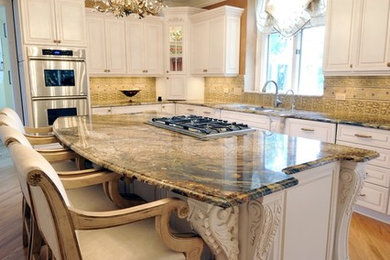 Inspiration for a large timeless l-shaped light wood floor and brown floor eat-in kitchen remodel in Chicago with a double-bowl sink, raised-panel cabinets, white cabinets, granite countertops, beige backsplash, stone tile backsplash, paneled appliances and an island