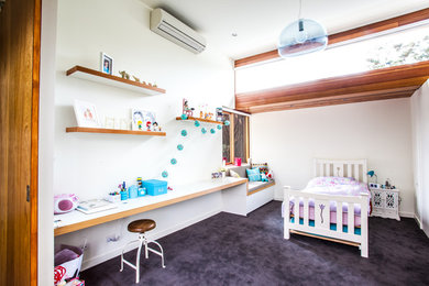 Design ideas for a modern kids' bedroom for kids 4-10 years old and girls in Melbourne with white walls and carpet.