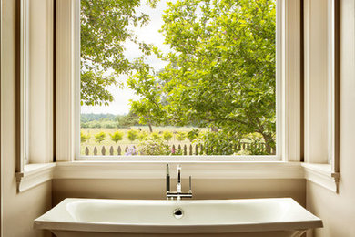 Freestanding bathtub - mid-sized traditional freestanding bathtub idea in Burlington with beige walls