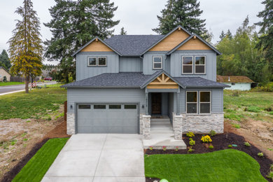 Photo of a contemporary two-storey grey house exterior in Portland with wood siding, a gable roof and a shingle roof.