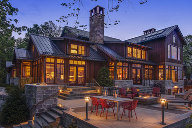 Inspiration for a country exterior in Milwaukee with stone veneer and a metal roof.