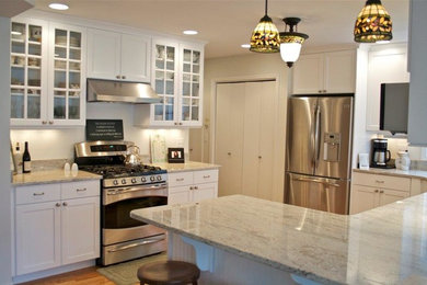 Kitchen - mid-sized traditional medium tone wood floor and brown floor kitchen idea in Other with a double-bowl sink, shaker cabinets, white cabinets, granite countertops, stainless steel appliances and a peninsula