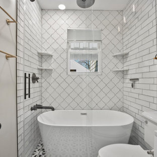 Immagine di una piccola stanza da bagno padronale minimalista con ante lisce, ante bianche, vasca freestanding, vasca/doccia, WC monopezzo, piastrelle bianche, piastrelle in ceramica, pareti grigie, pavimento in legno massello medio, lavabo da incasso, top in quarzo composito, pavimento marrone, porta doccia scorrevole, top grigio, un lavabo e mobile bagno freestanding