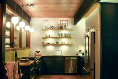 Inspiration for a 1960s u-shaped cork floor eat-in kitchen remodel in Denver with an undermount sink, flat-panel cabinets, gray cabinets, solid surface countertops, white backsplash, ceramic backsplash and stainless steel appliances