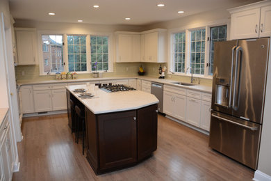 Example of a large transitional u-shaped medium tone wood floor and brown floor open concept kitchen design in DC Metro with a single-bowl sink, recessed-panel cabinets, white cabinets, quartz countertops, green backsplash, glass tile backsplash, stainless steel appliances, an island and white countertops