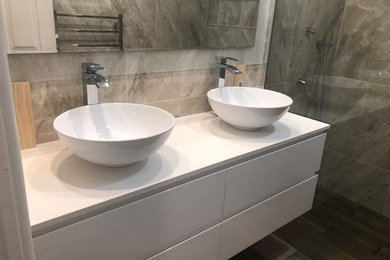 This is an example of a mid-sized modern master bathroom in Melbourne with an open shower, brown tile, ceramic tile, ceramic floors and brown floor.