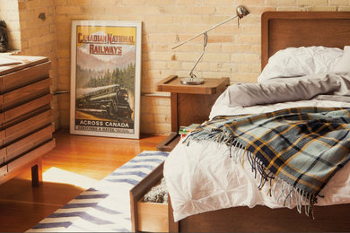 Example of a large minimalist light wood floor and brown floor bedroom design in Chicago with beige walls and no fireplace