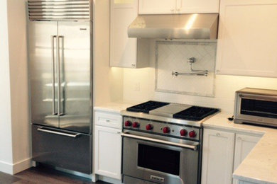 Mid-sized trendy u-shaped dark wood floor and brown floor eat-in kitchen photo in San Francisco with shaker cabinets, white cabinets, white backsplash, ceramic backsplash, stainless steel appliances, no island and granite countertops