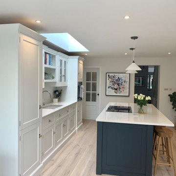 Open plan off-white handmade kitchen with navy contrasting island