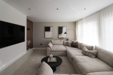 Photo of a large modern home cinema in Edinburgh with beige walls, carpet, a wall mounted tv, beige floors and feature lighting.
