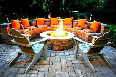 Inspiration for a mid-sized farmhouse backyard concrete paver patio remodel in Toronto with a fire pit