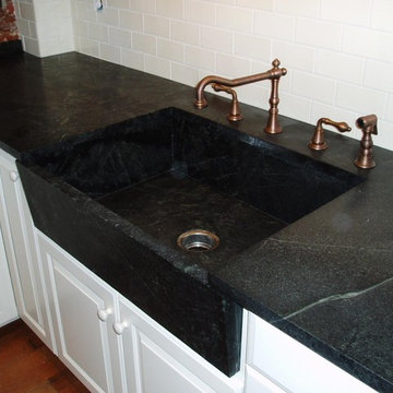 A Traditional White Kitchen with Soapstone Countertops and Custom Built Sink
