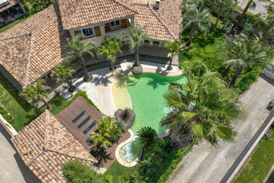 Foto di una grande piscina tropicale personalizzata con paesaggistica bordo piscina