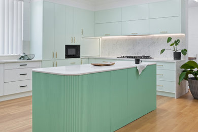 Design ideas for a kitchen in Sydney with green cabinets, quartz benchtops, white splashback, engineered quartz splashback and with island.