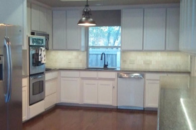 Example of a mid-sized minimalist dark wood floor open concept kitchen design in Dallas with a double-bowl sink, white cabinets, granite countertops, white backsplash, ceramic backsplash and stainless steel appliances