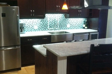 Open concept kitchen - small contemporary galley light wood floor open concept kitchen idea in San Francisco with a farmhouse sink, shaker cabinets, dark wood cabinets, marble countertops, green backsplash, mosaic tile backsplash, stainless steel appliances and an island