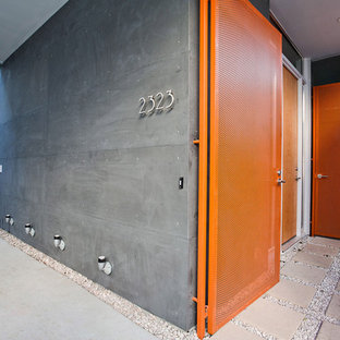 Ispirazione per un ingresso o corridoio design con una porta singola e una porta arancione