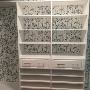 Foto di una piccola cabina armadio per donna classica con ante con bugna sagomata, ante bianche, pavimento in legno massello medio e pavimento arancione