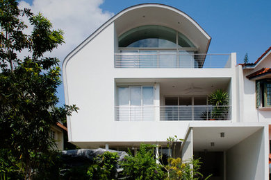 Inspiration for a contemporary three-storey stucco white exterior in Singapore.