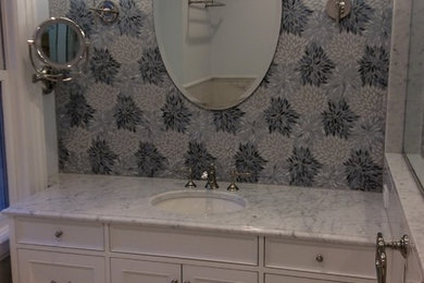 Bathroom - traditional multicolored tile and glass sheet marble floor bathroom idea in New York with beaded inset cabinets, white cabinets, a two-piece toilet, an undermount sink, marble countertops and a hinged shower door
