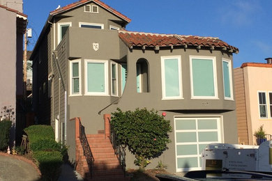 This is an example of a traditional two-storey grey house exterior in San Francisco with mixed siding, a shed roof and a shingle roof.
