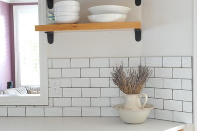 Kitchen - traditional kitchen idea in Vancouver with medium tone wood cabinets, an island and white countertops