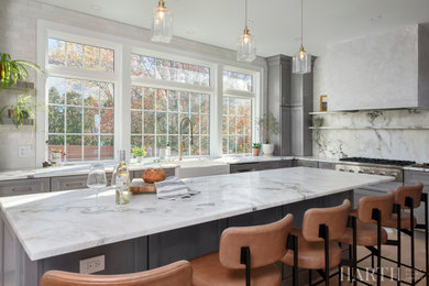 Large transitional u-shaped medium tone wood floor and brown floor eat-in kitchen photo in Philadelphia with a farmhouse sink, recessed-panel cabinets, gray cabinets, quartz countertops, multicolored backsplash, quartz backsplash, stainless steel appliances, an island and multicolored countertops