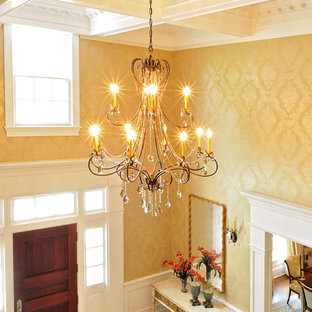 ニューヨークの大きい片開きドアトラディショナルスタイルのおしゃれな玄関ロビー (メタリックの壁、トラバーチンの床、木目調のドア) の写真