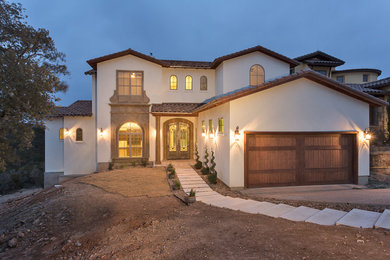 Inspiration for a large mediterranean two-storey stucco beige exterior in Austin.