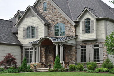Example of a huge transitional multicolored two-story mixed siding exterior home design in Cleveland with a shingle roof